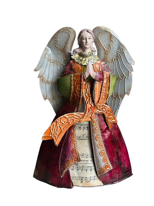 Angelo in metallo decorato che prega vestito con spartito