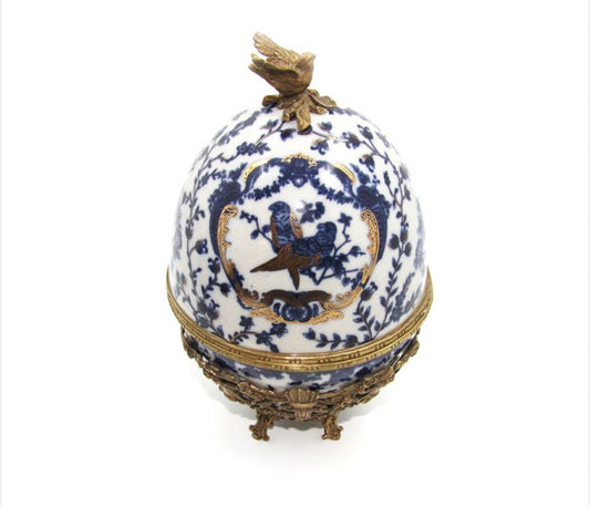 Uovo in ceramica blu con uccellino e base in bronzo
